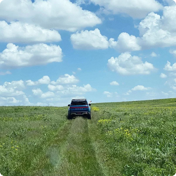 Rivian R1T driving through scenic landscape
